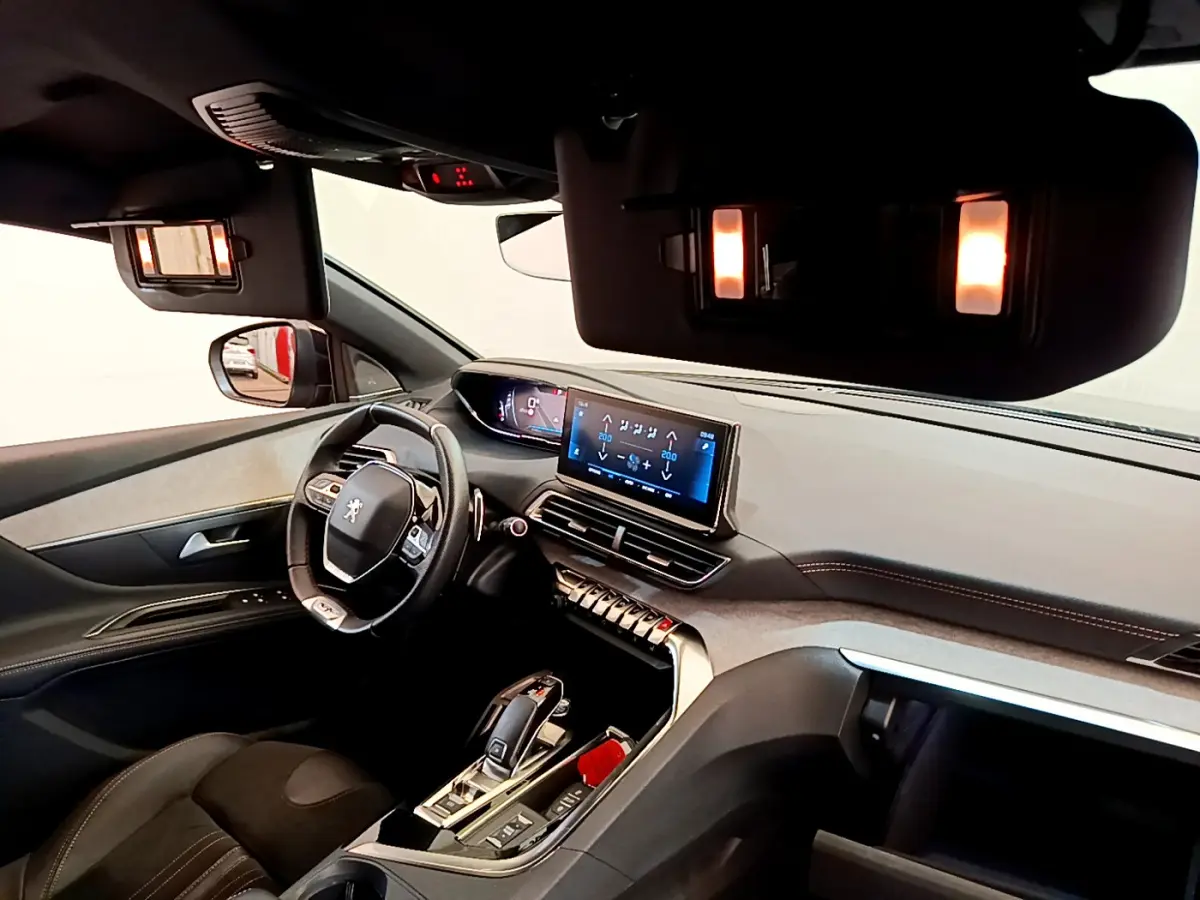 Intérieur Peugeot 5008 GT Pack 2021 vu côté conducteur, tableau de bord moderne avec écran tactile et éclairage ambiant.