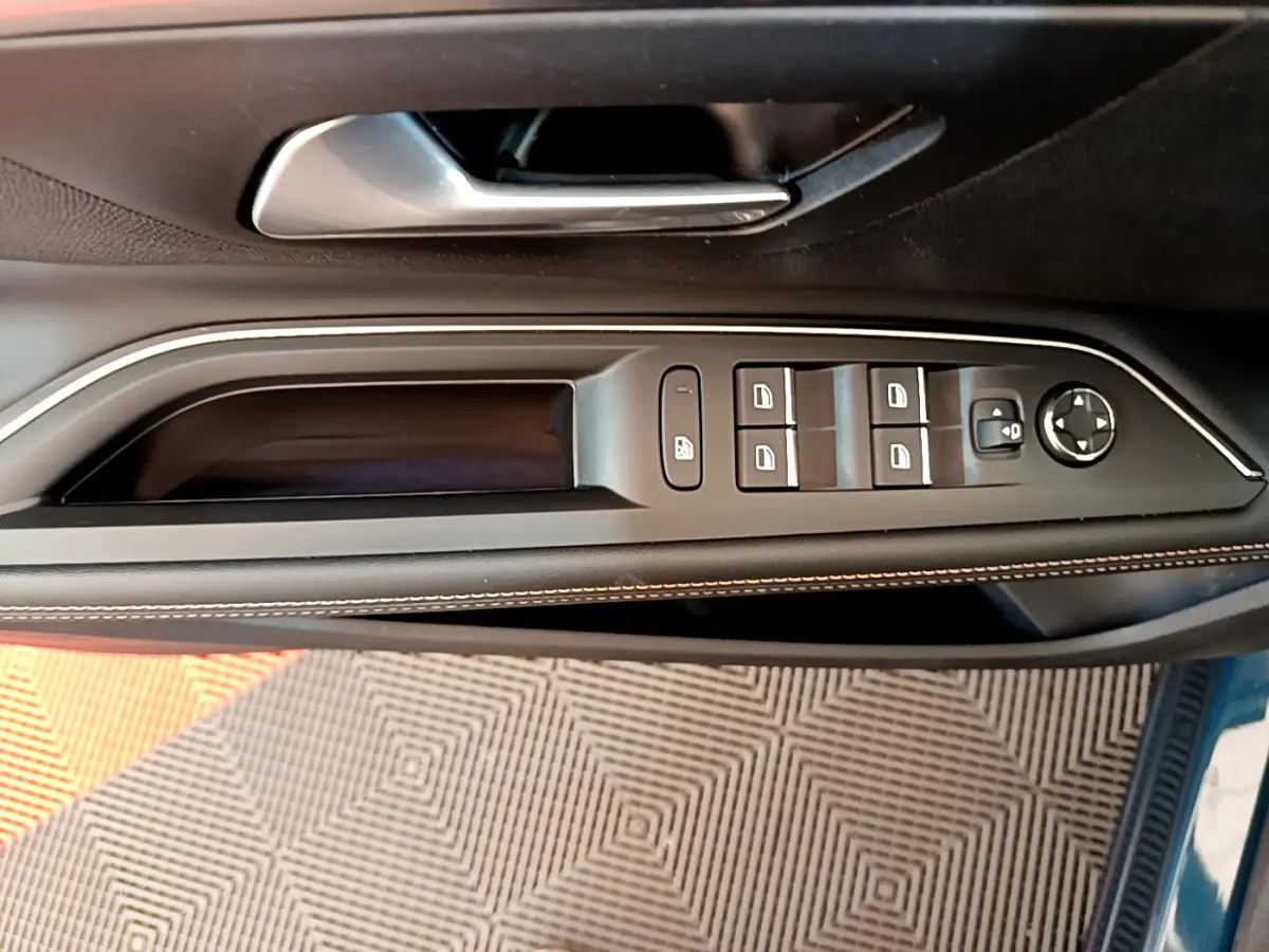 Vue rapprochée de la porte côté conducteur du Peugeot 5008 bleu, avec commandes des vitres et rétroviseurs intégrées.
