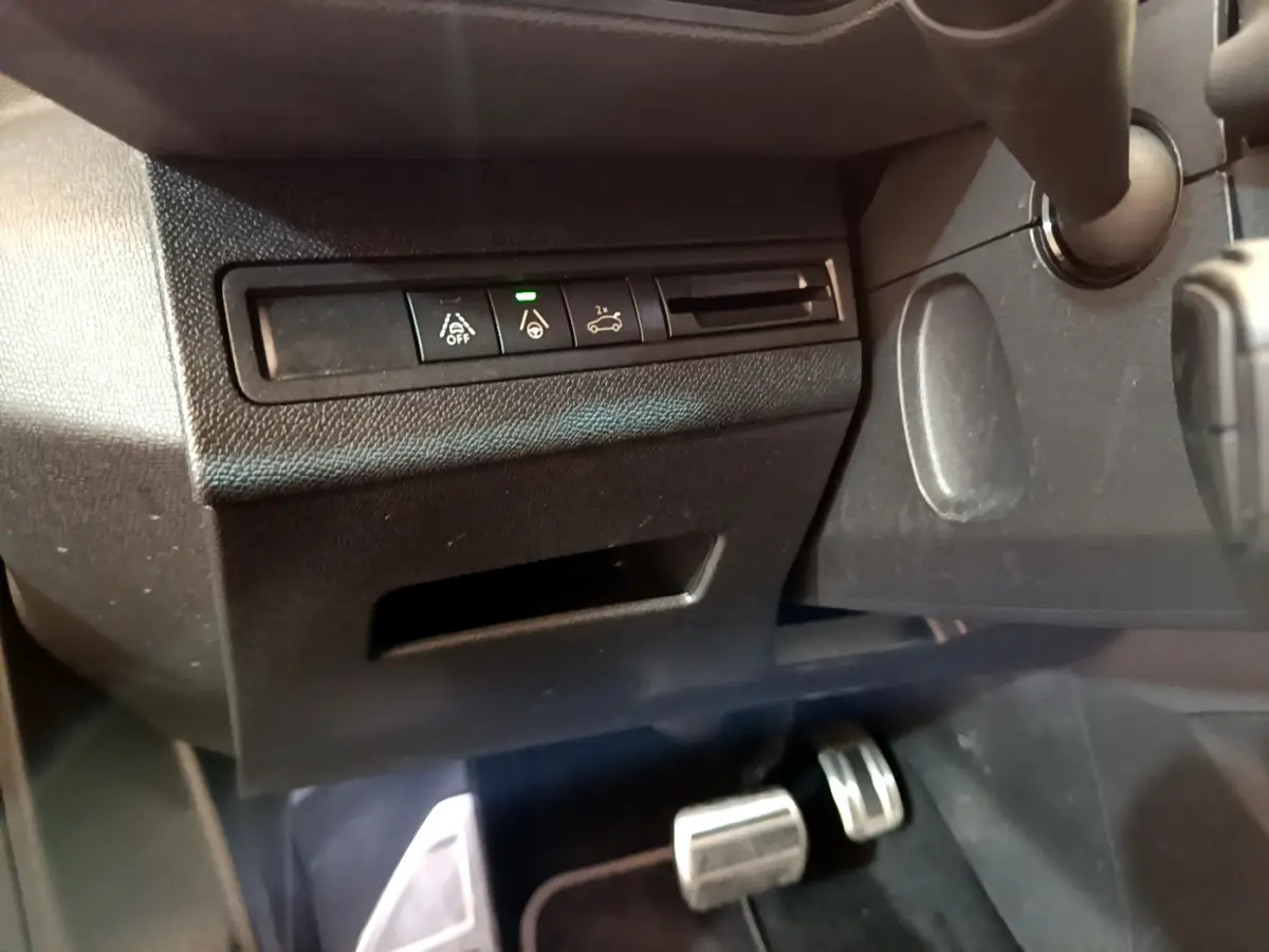 Vue rapprochée du tableau de bord côté conducteur du Peugeot 5008 bleu, avec commandes d'aide à la conduite et pédales alu.
