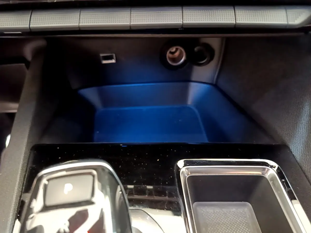 Gros plan sur la console centrale noire brillante du Peugeot 5008 GT Pack 2021 avec bouton de frein à main électrique.
