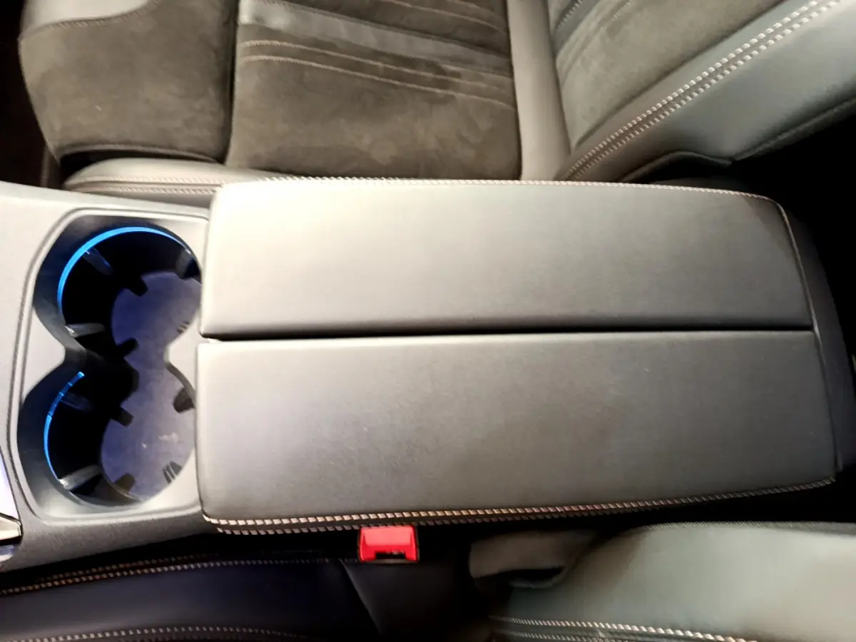 Gros plan sur l'accoudoir central noir et porte-gobelets éclairé à l'intérieur du Peugeot 5008 GT Pack 2021.