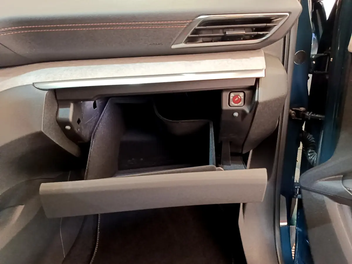 Vue intérieure côté passager du Peugeot 5008 bleu 2021, avec boîte à gants ouverte et tableau de bord gris anthracite.