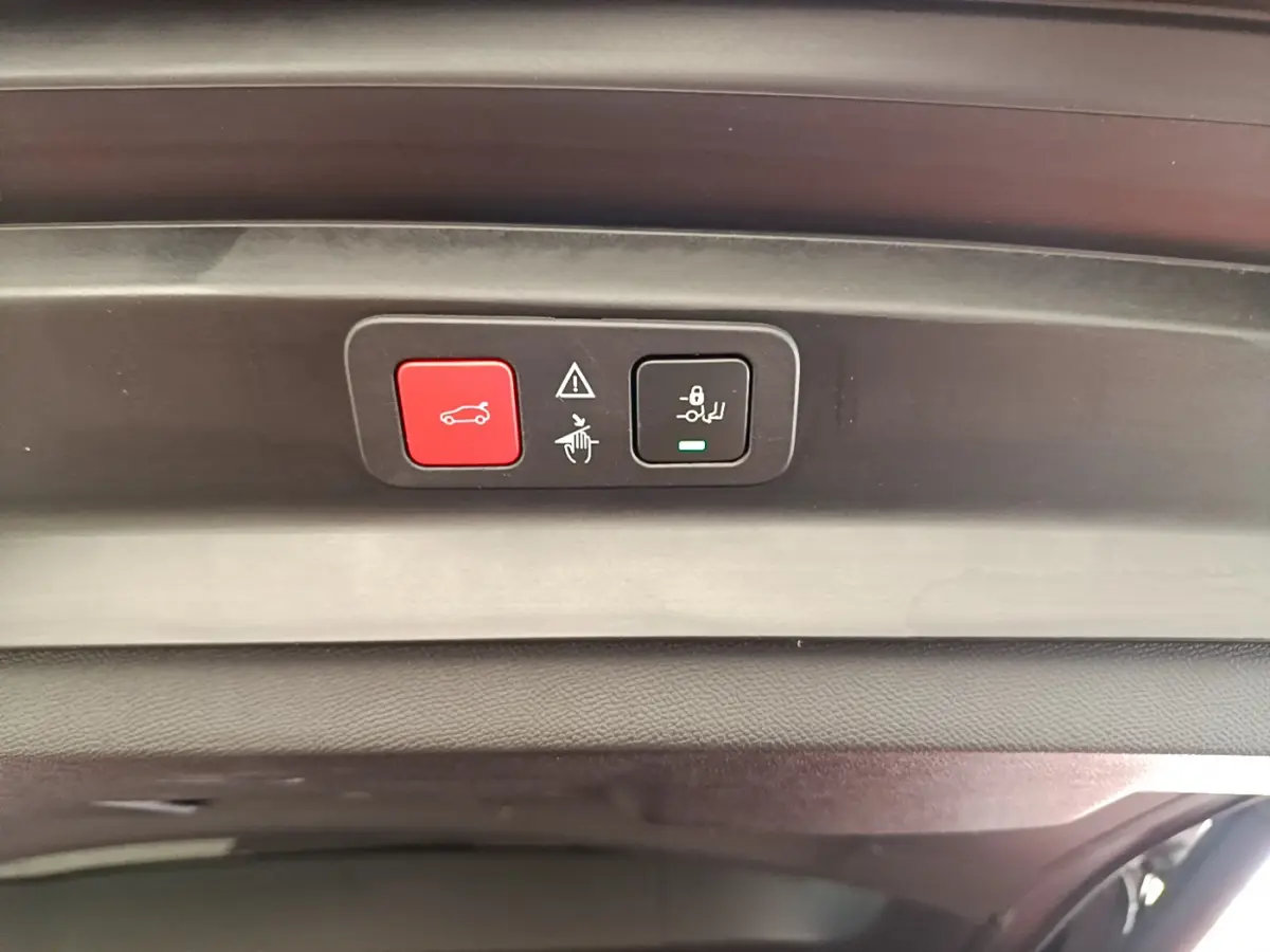 Boutons de commande rouge et noir sur le hayon intérieur du coffre du Peugeot 5008 bleu 2021.
