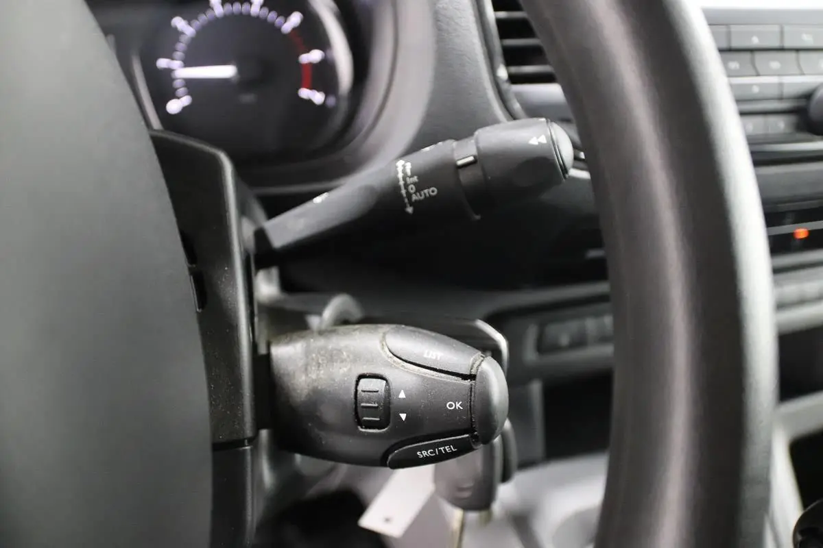 Gros plan sur la commande au volant du Citroën Jumpy Fourgon XL blanc, mettant en valeur les boutons de contrôle audio et téléphone.