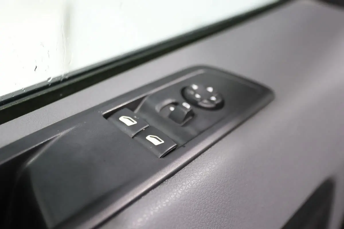 Gros plan sur les commandes de lève-vitres et rétroviseurs côté conducteur du Citroën Jumpy Fourgon XL blanc 2019.