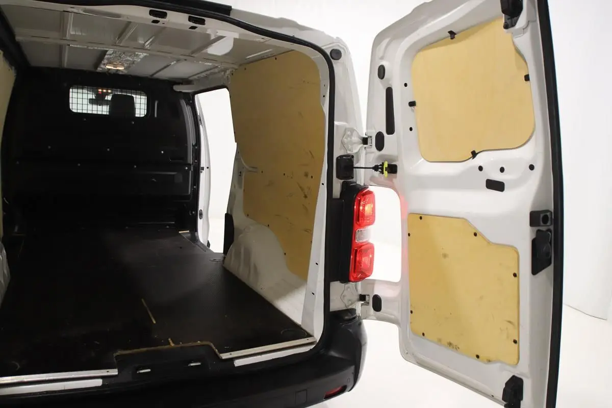 Intérieur du fourgon blanc Citroën Jumpy XL 2019 vu par l'arrière avec portes ouvertes et aménagement bois.