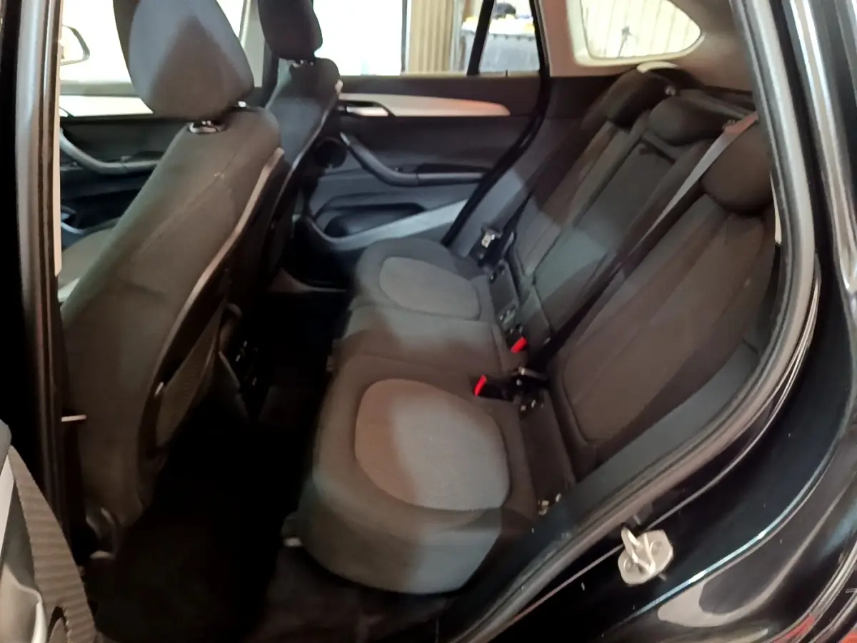 Vue intérieure côté droit montrant la banquette arrière noire du BMW X1 sDrive16d Business Design 2020.