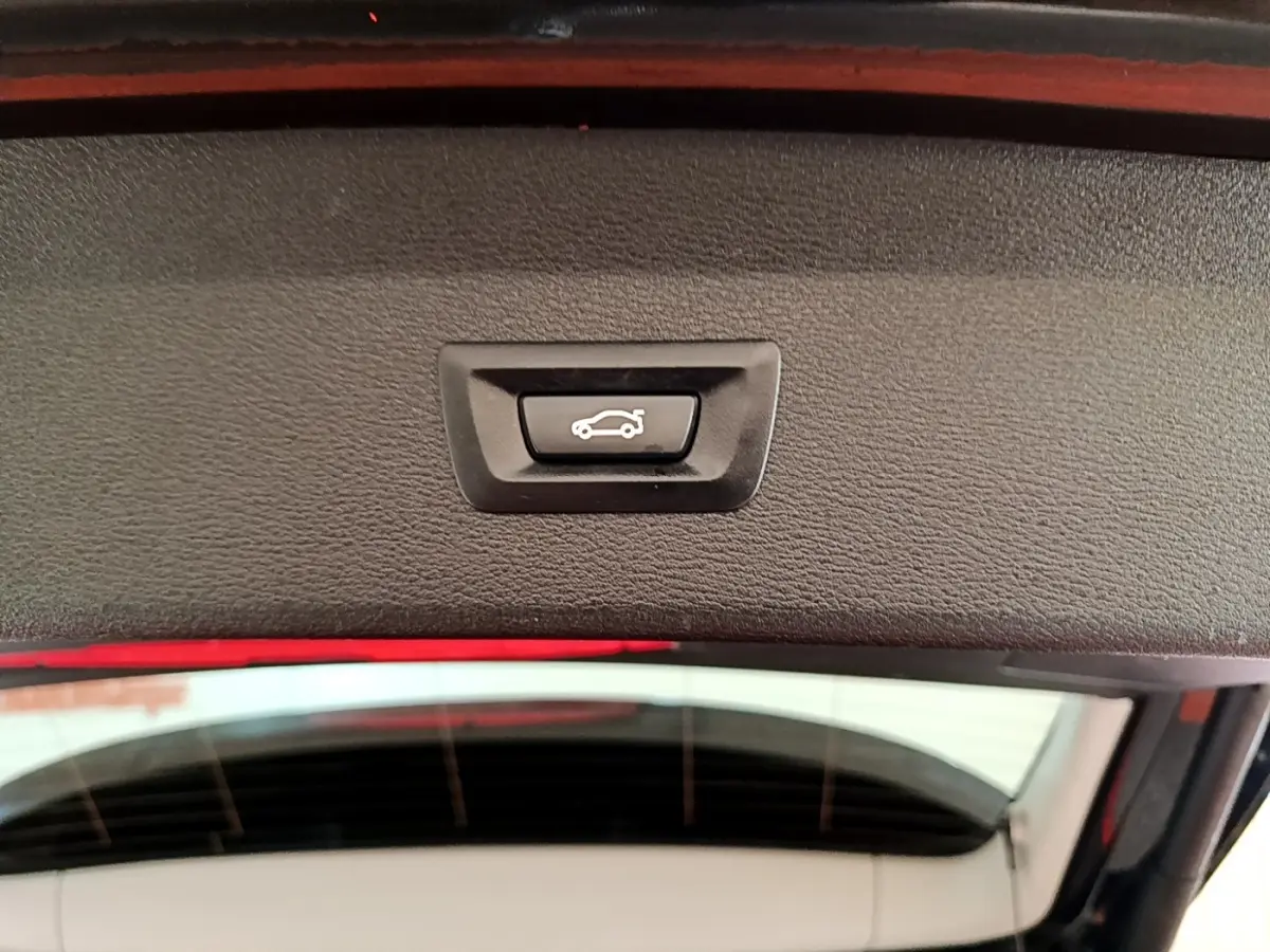 Bouton de fermeture électrique du coffre vu de l'intérieur du hayon d'un BMW X1 noir 2020 sDrive16d Business Design DKG7.
