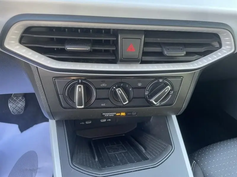 Vue rapprochée du tableau de bord central du SEAT Arona noir 2023, montrant les commandes de climatisation et les aérateurs.