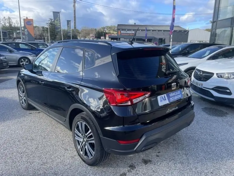 Vue 3/4 arrière droite d’un SEAT Arona noir 2023, avec feux arrière LED et jantes alliage visibles.