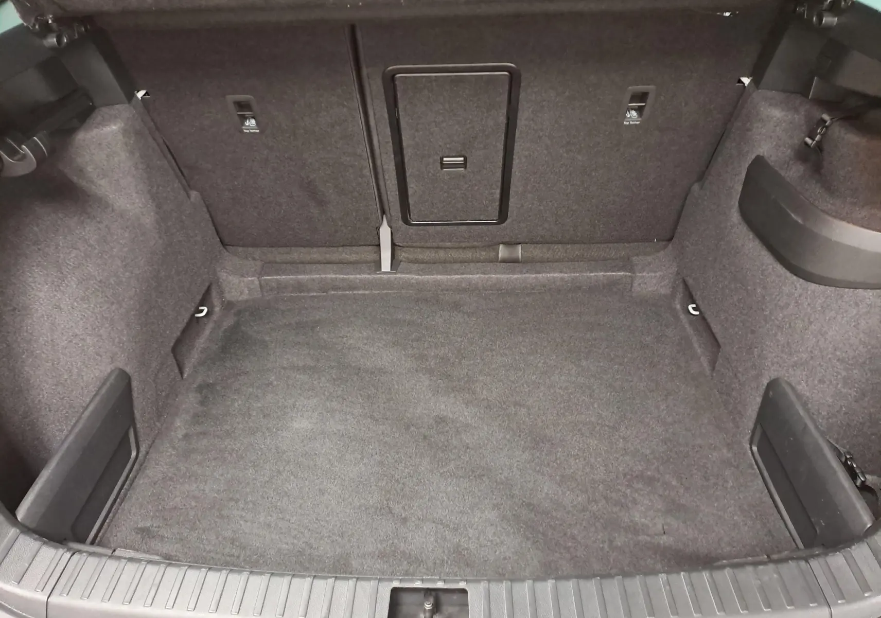 Coffre spacieux et vide du Skoda Karoq 1.5 TSI 150 DSG7 blanc lune, vue intérieure depuis l'arrière.