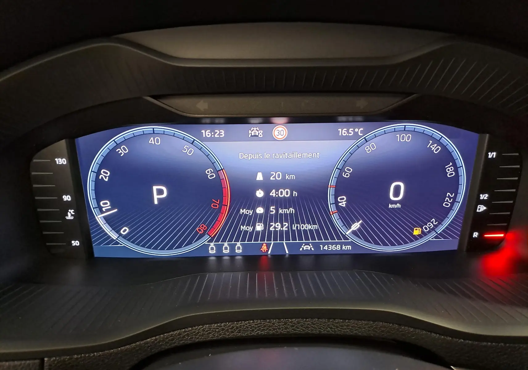 Vue rapprochée du tableau de bord numérique du Skoda Karoq 2025, affichant la vitesse, la température et l'autonomie.