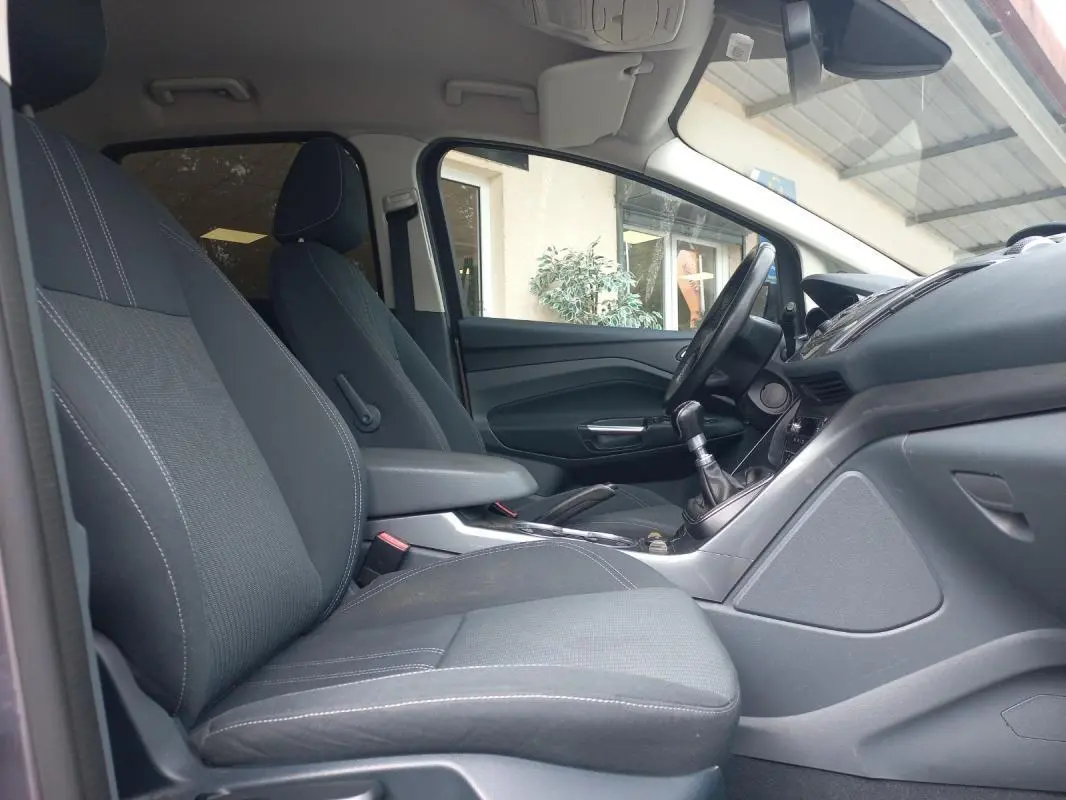 Vue intérieure côté droit du Ford C-MAX gris 2015, montrant les sièges avant et la console avec levier de vitesses manuel.