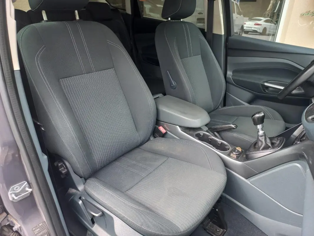 Vue intérieure côté gauche du Ford C-MAX gris 2015, montrant les sièges avant et la boîte manuelle.
