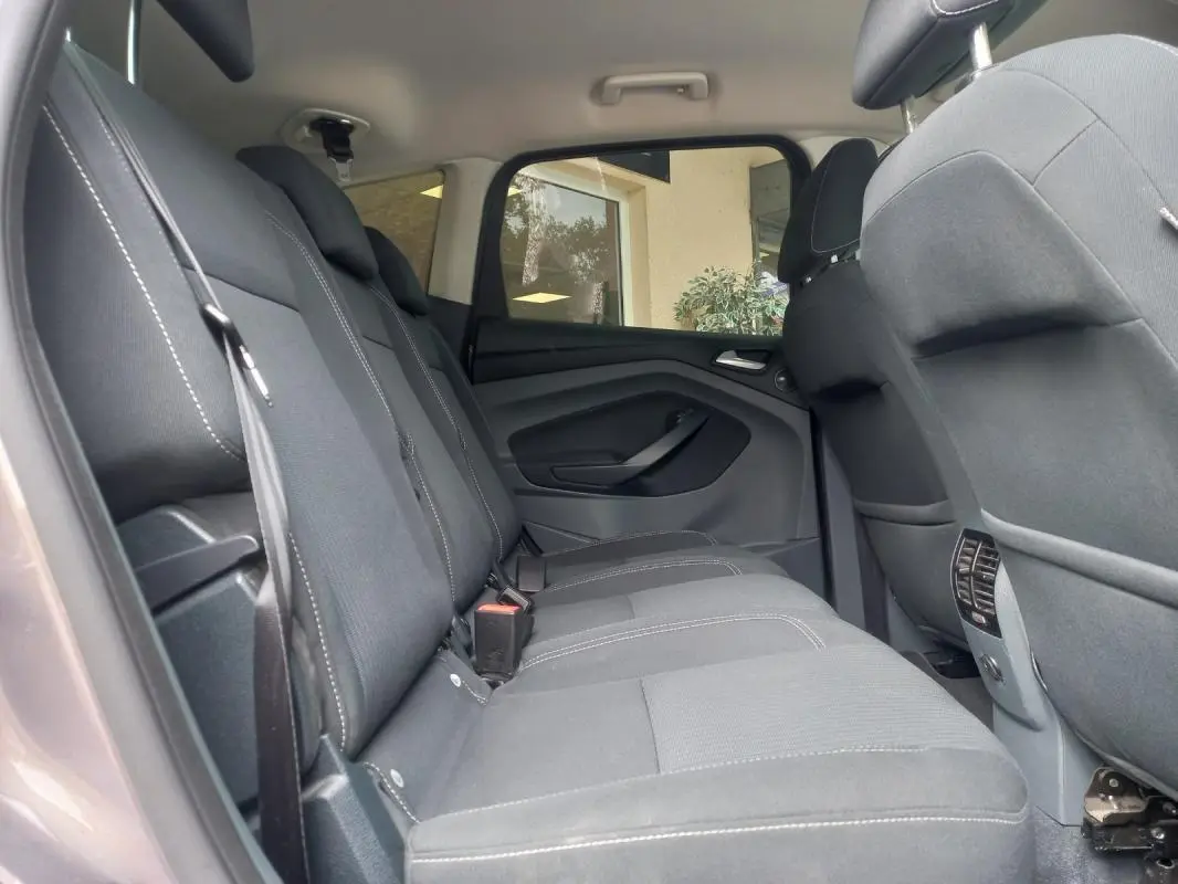 Vue intérieure côté gauche des sièges arrière gris du Ford C-MAX 2015, version Titanium X avec ceintures visibles.