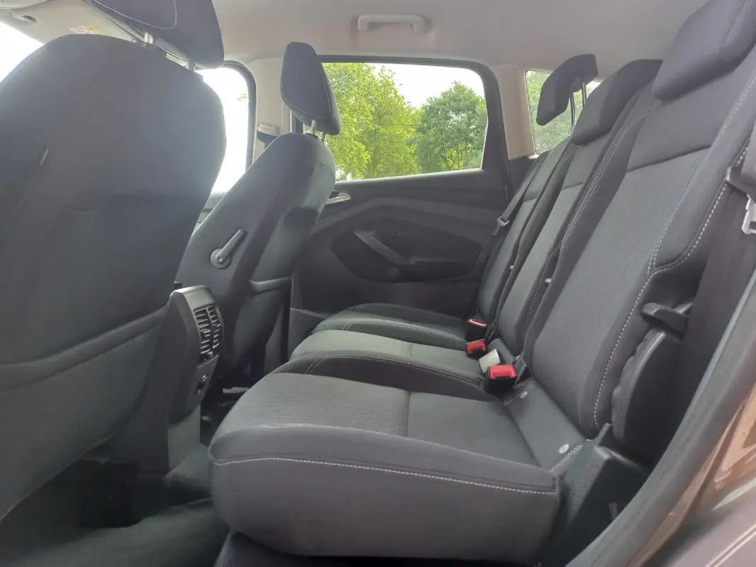 Vue intérieure côté droit des sièges arrière noirs du Ford C-MAX gris 2015 version Titanium X, avec ceintures visibles.