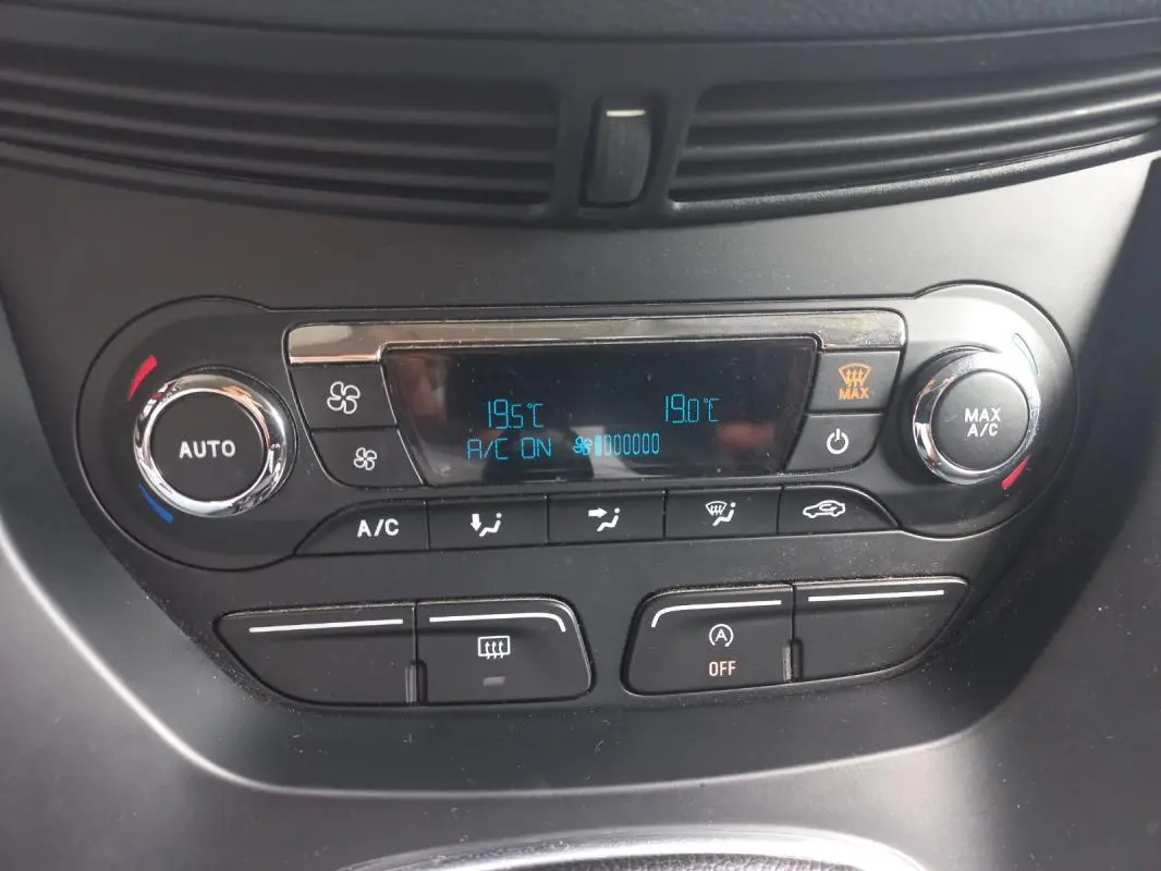 Vue rapprochée de la console de climatisation du Ford C-MAX gris 2015 avec affichage digital et commandes circulaires.