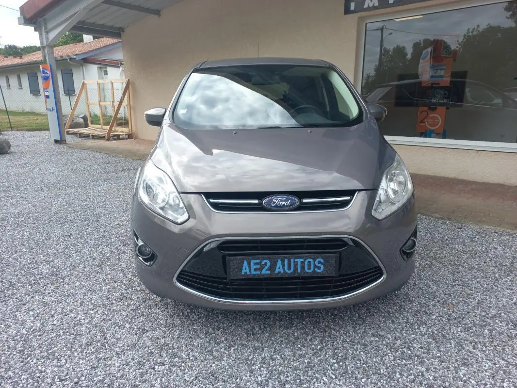 Vue frontale d'une Ford C-MAX gris métallisé 2015 avec calandre noire et plaque AE2 AUTOS.