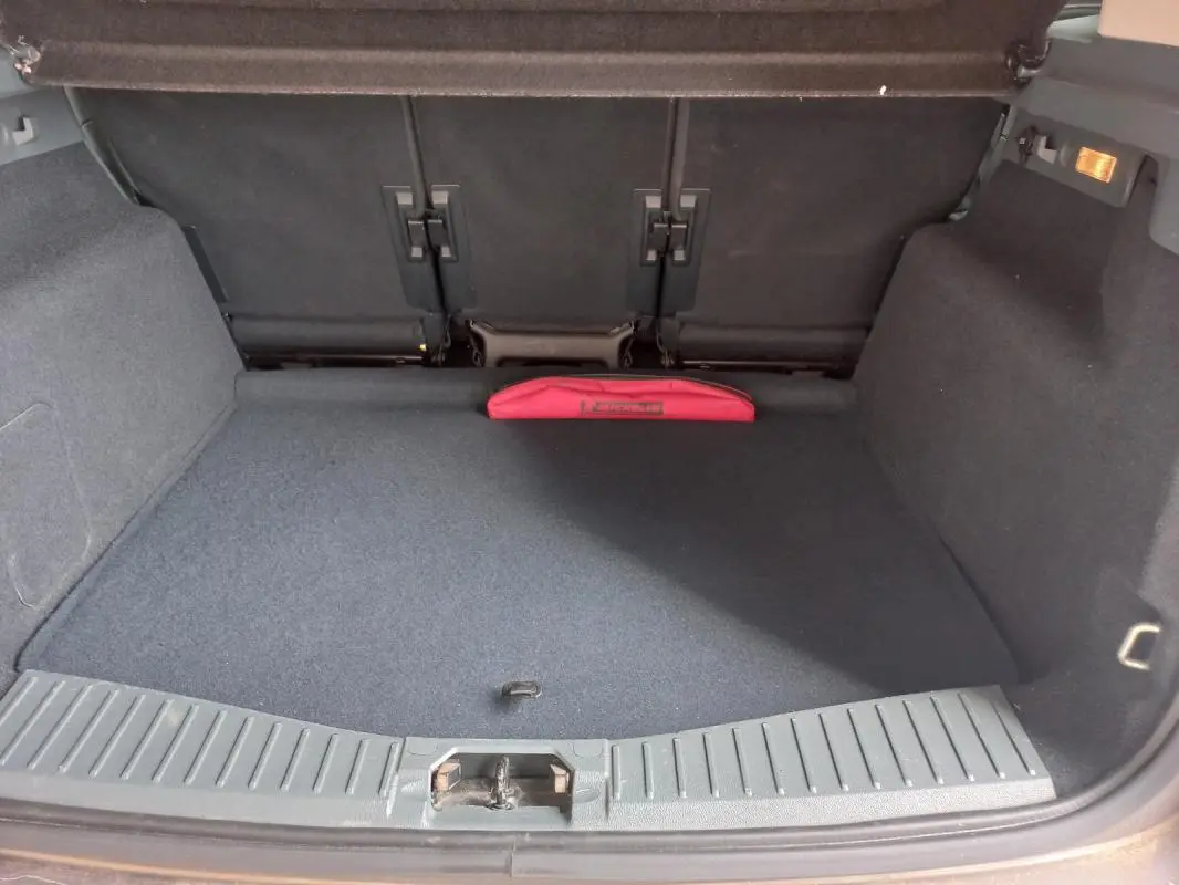 Vue intérieure du coffre gris du Ford C-MAX 2015, avec un rangement rouge visible à l'arrière.