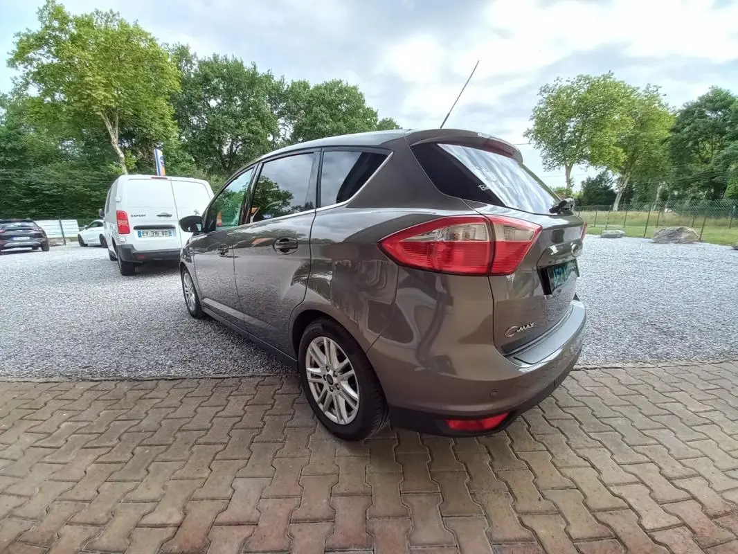 Vue 3/4 arrière droite d'une Ford C-MAX gris métallisé 2015 avec jantes alliage et vitres teintées.