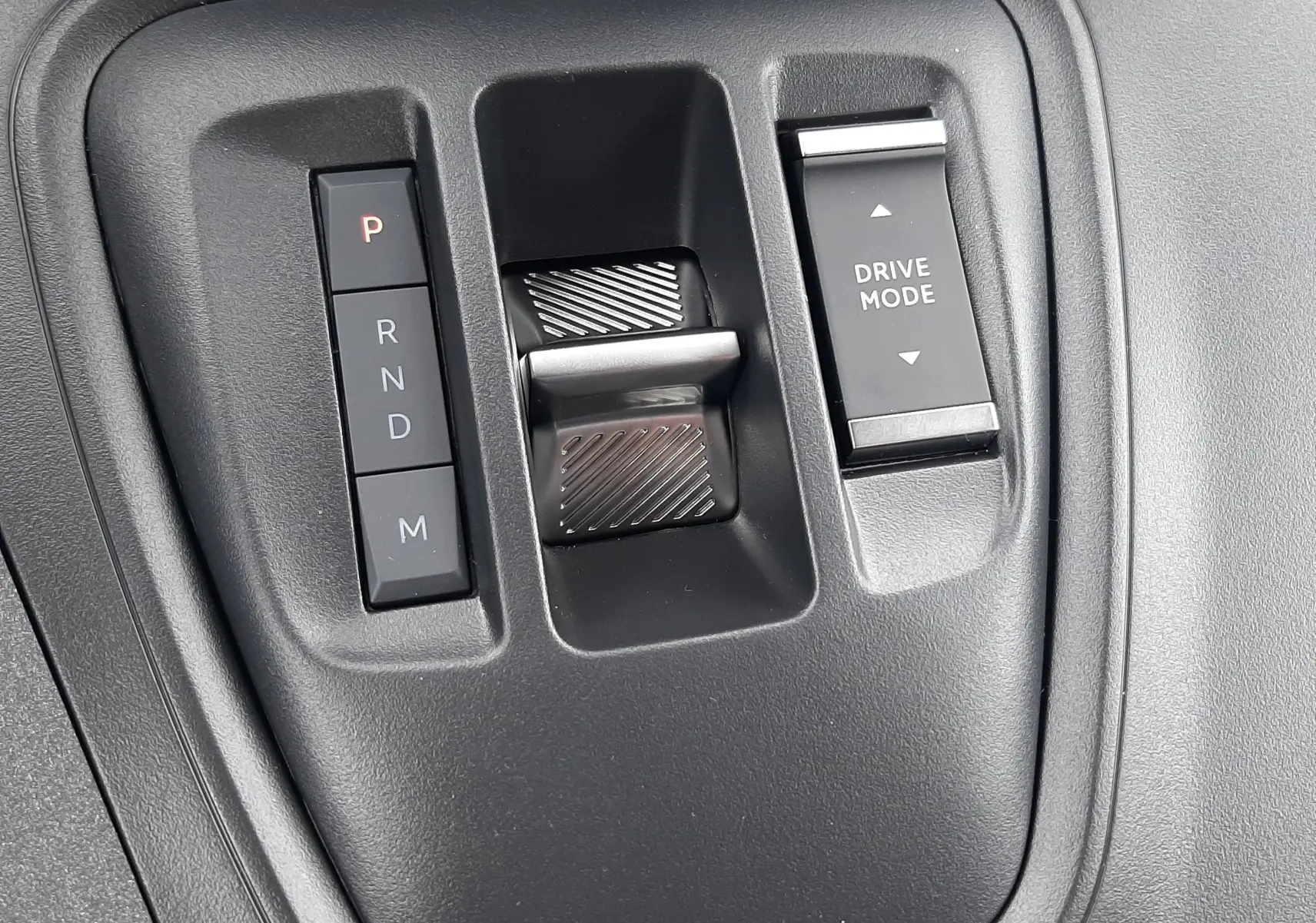 Gros plan sur la commande de boîte automatique et le sélecteur Drive Mode du Peugeot Rifter III Ph.2 intérieur noir.