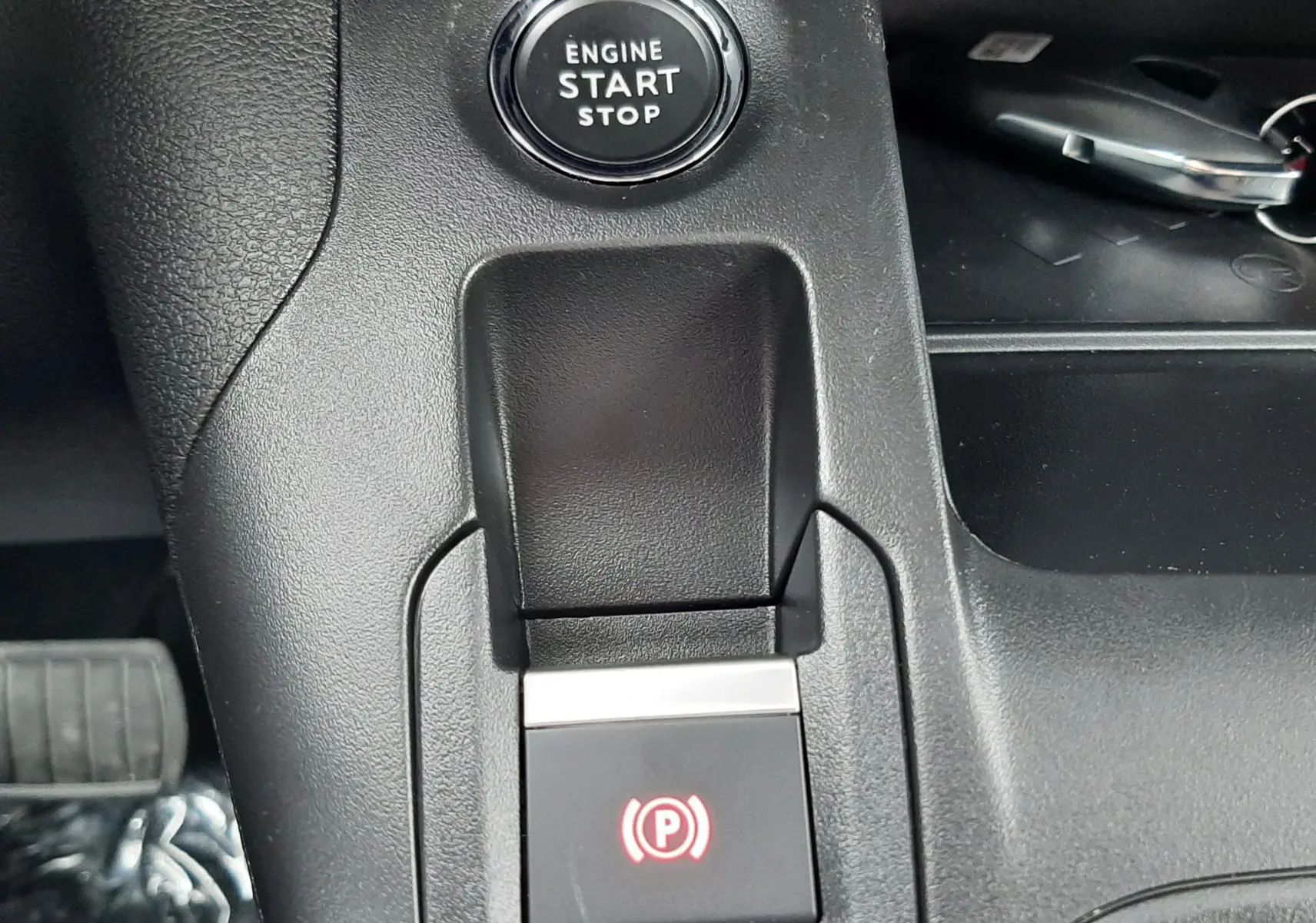 Gros plan sur le bouton Start/Stop moteur et la commande de frein à main électrique du Peugeot Rifter III Ph.2.