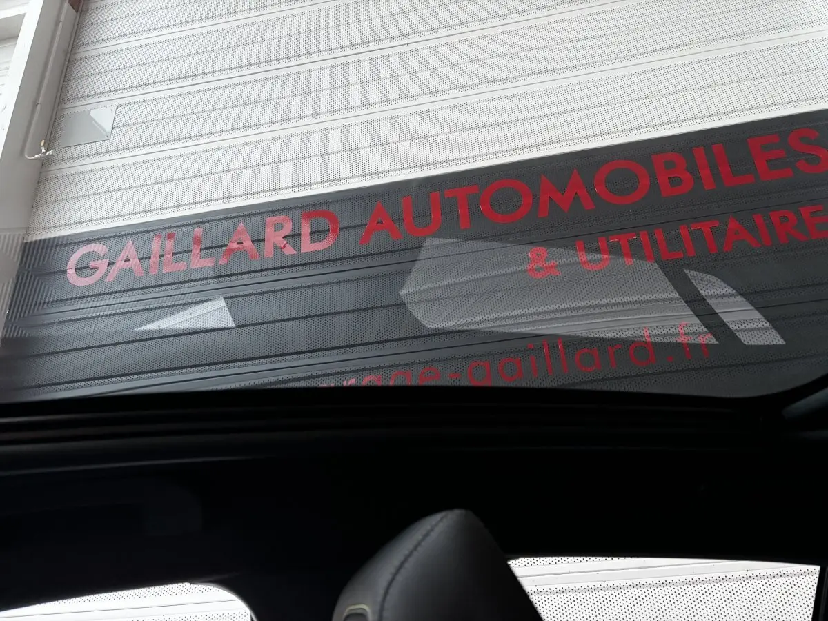 Vue intérieure arrière de la Peugeot 208 Hybrid 136 eDCS6 GT gris foncé avec toit ouvrant panoramique visible