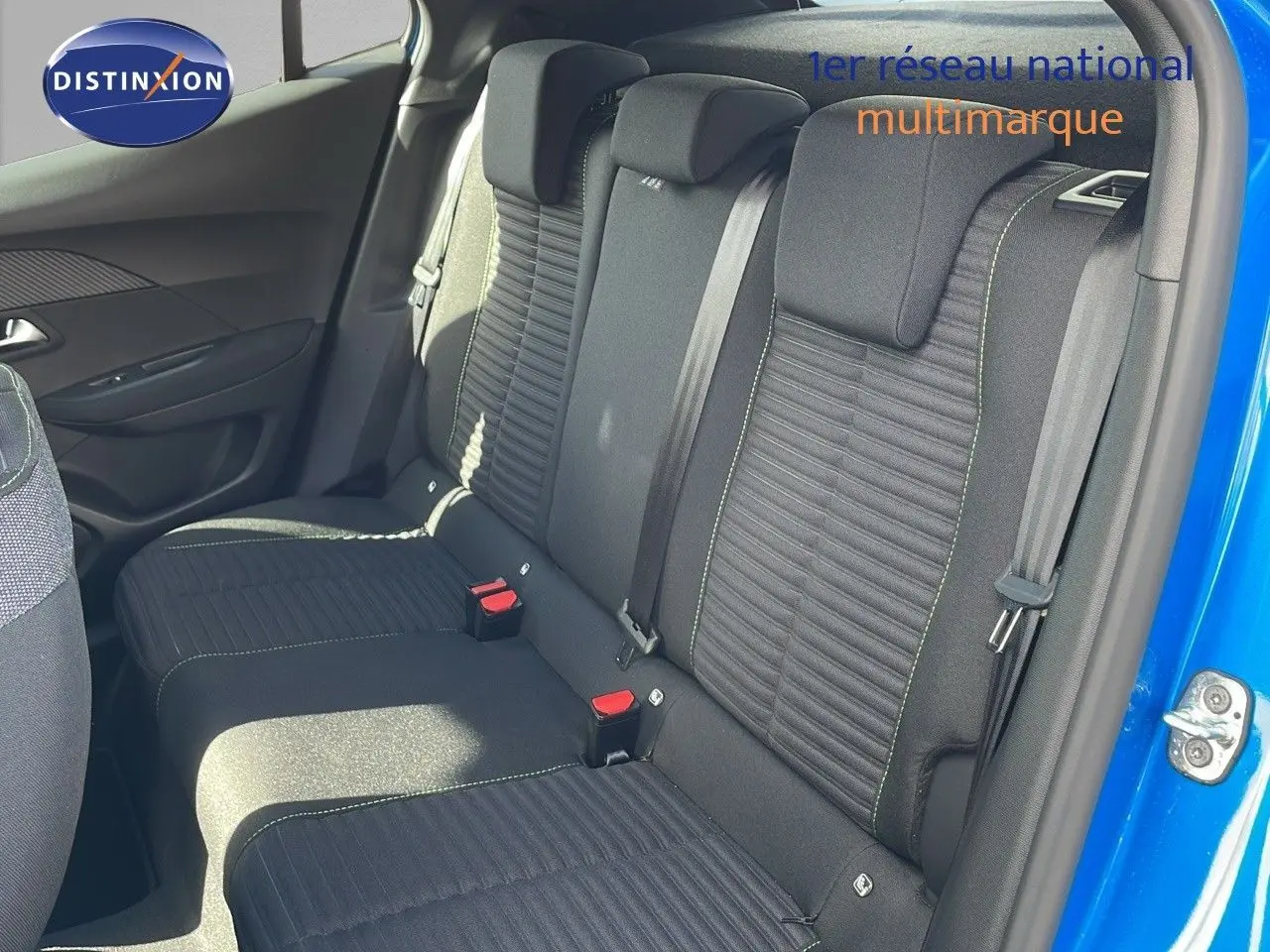 Vue intérieure sur la banquette arrière noire avec surpiqûres vertes d'une Peugeot 2008 bleu Vertigo 2024, porte ouverte côté droit.