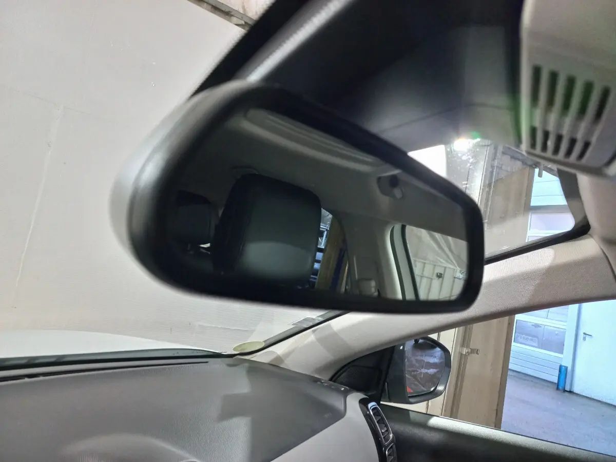 Vue intérieure du rétroviseur central du Citroën C5 Aircross blanc, montrant l'appui-tête arrière et le tableau de bord noir.