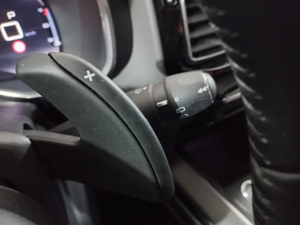 Gros plan sur la palette de changement de vitesse "+" côté droit du volant cuir du Citroën C5 Aircross blanc de 2020.