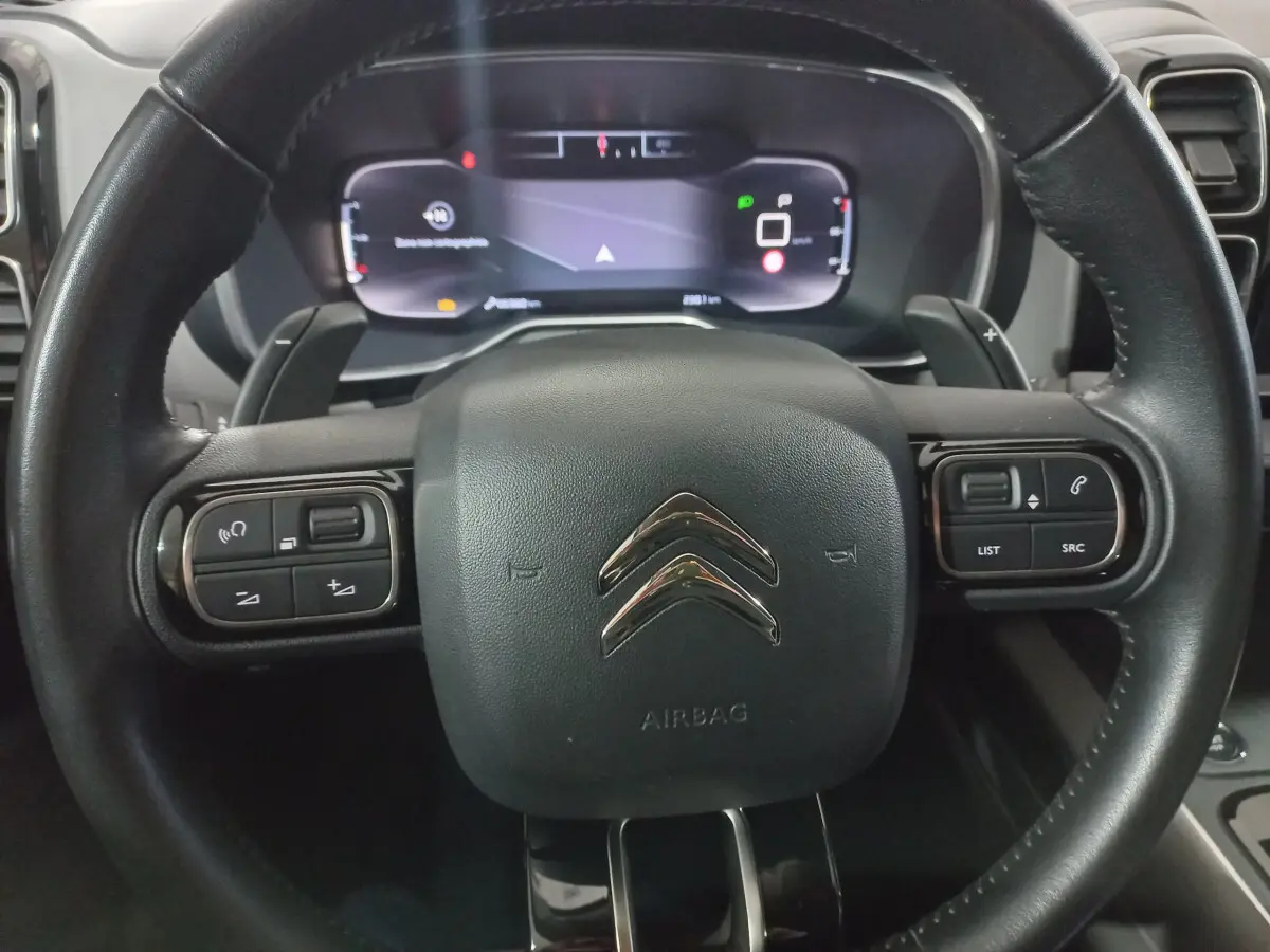 Gros plan sur le volant cuir noir de la Citroën C5 Aircross 2020 avec commandes intégrées et tableau de bord numérique.