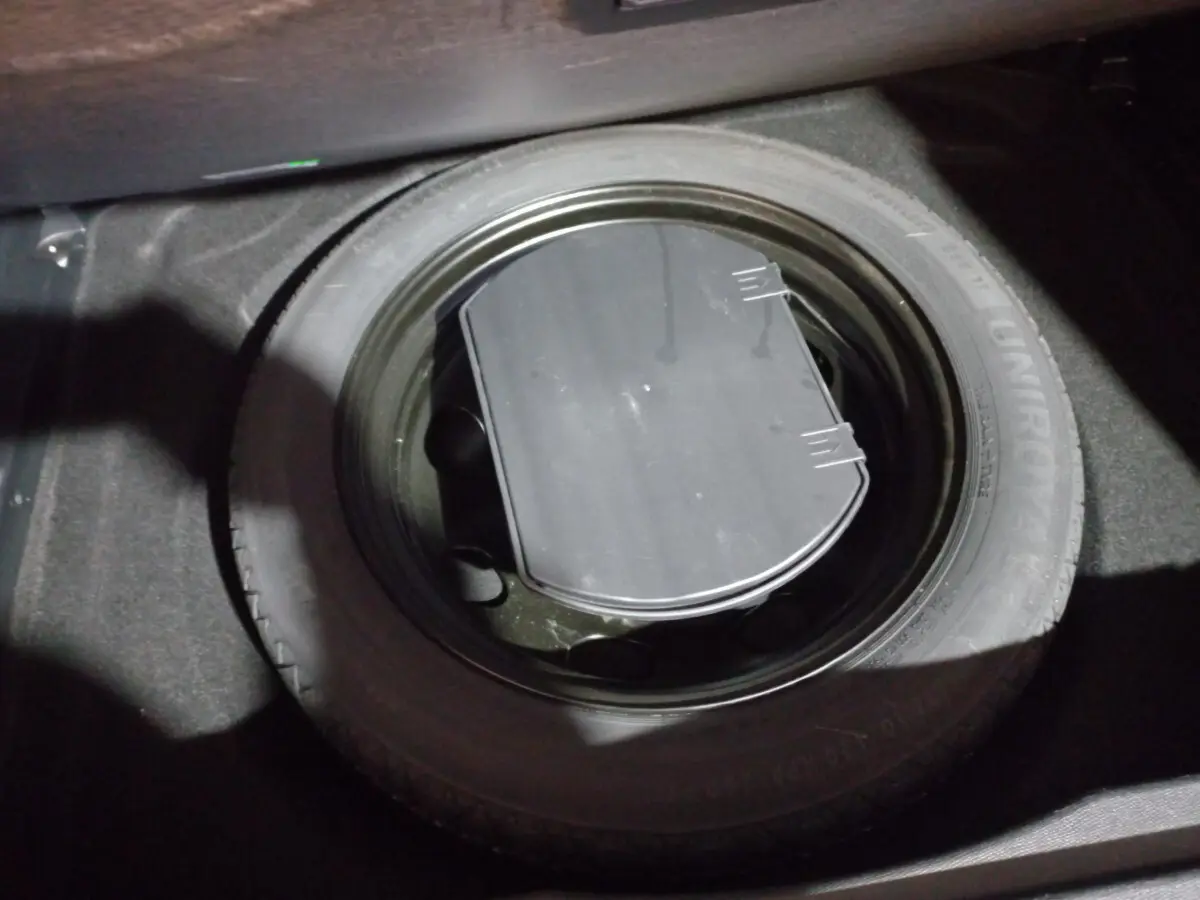 Gros plan sur la roue de secours noire dans le coffre du Citroën C5 Aircross blanc de 2020.