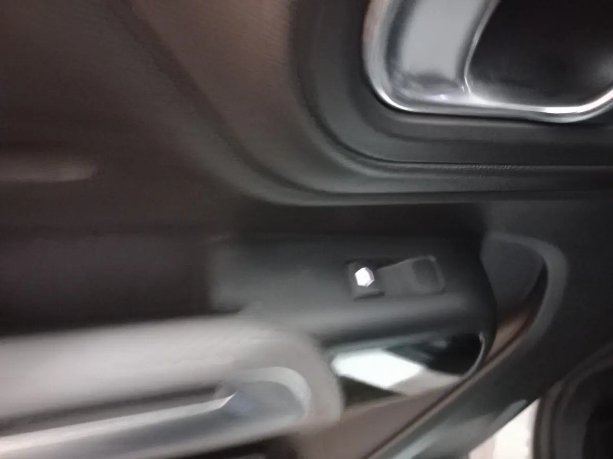 Poignée intérieure de porte côté droit du Citroën C5 Aircross 2020 avec commandes de vitre et finition noire.