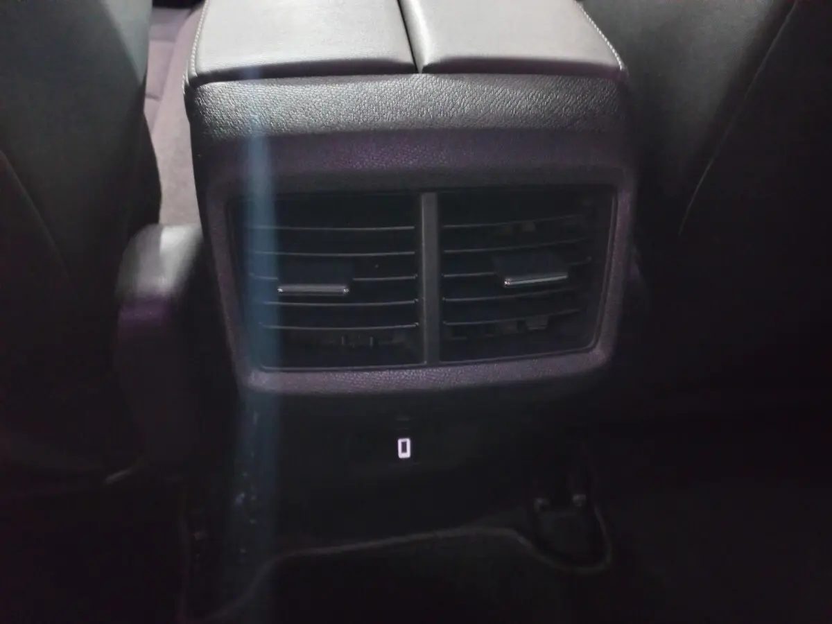 Bouche d'aération arrière noire vue de près entre les sièges arrière du Citroën C5 Aircross blanc 2020.