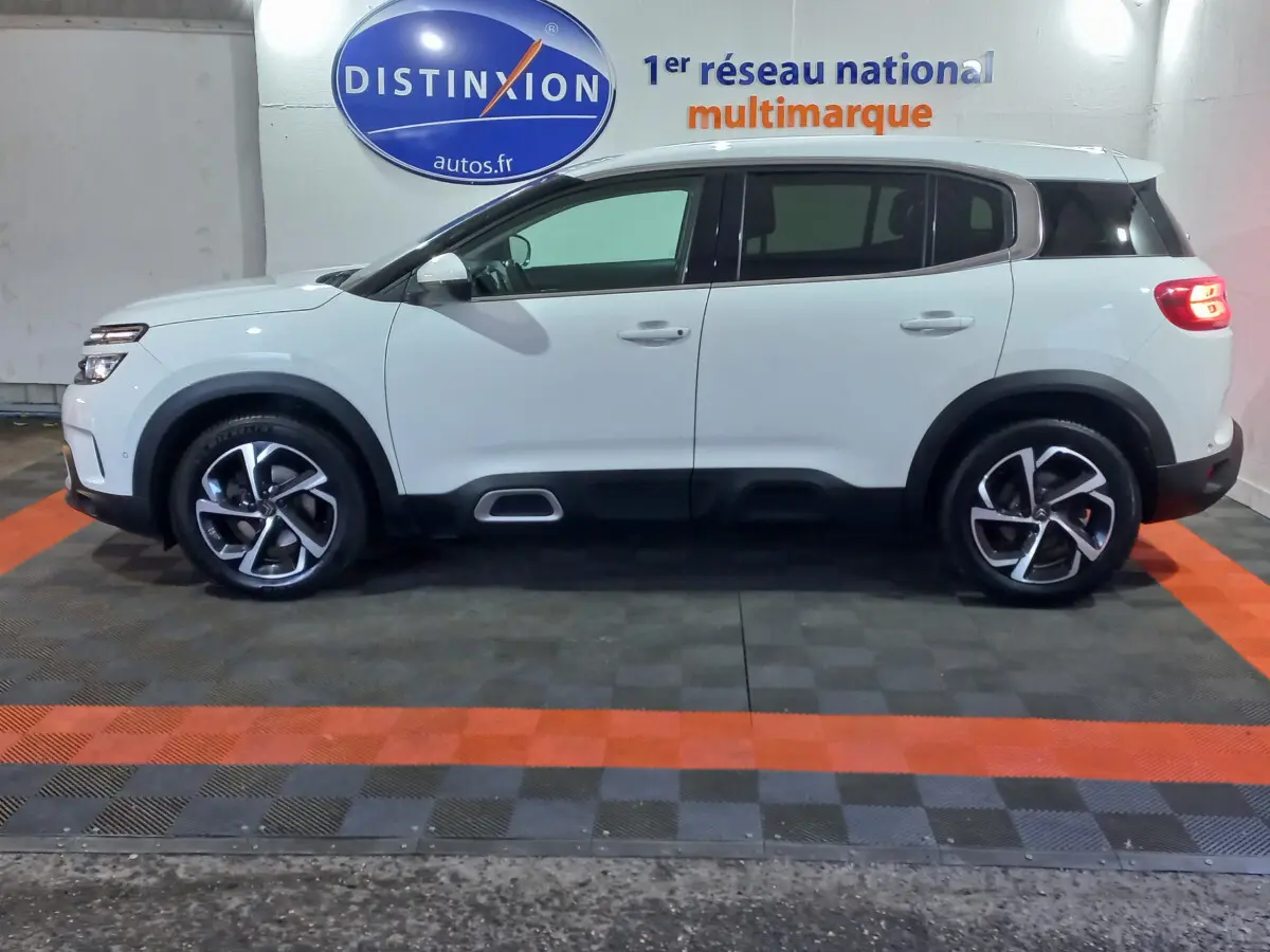 Profil droit d'un Citroën C5 Aircross blanc 2020 avec jantes alliage et protections noires sur bas de caisse.