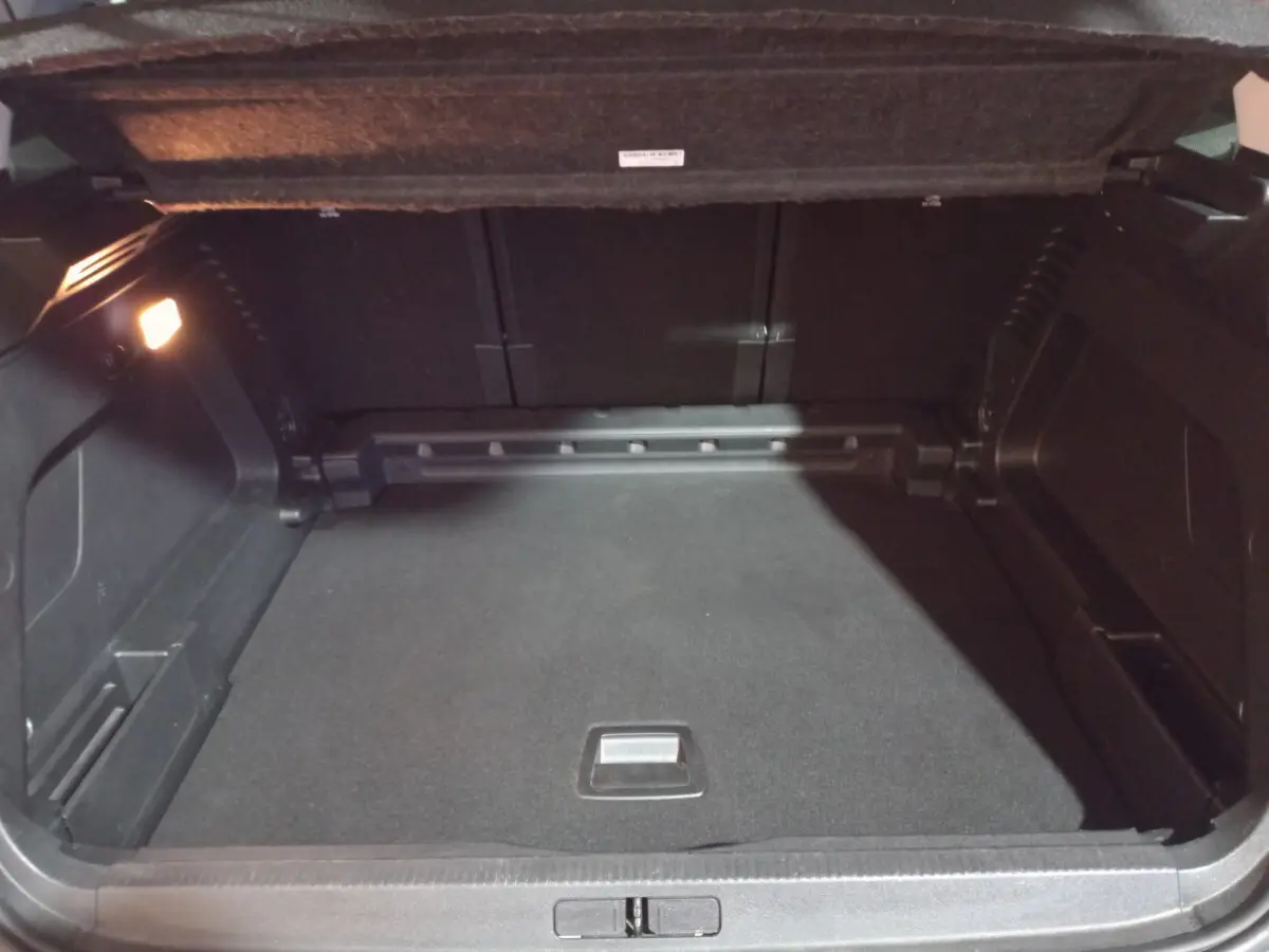 Coffre ouvert du Citroën C5 Aircross blanc 2020, vue intérieure montrant un espace de rangement noir et éclairé à gauche.