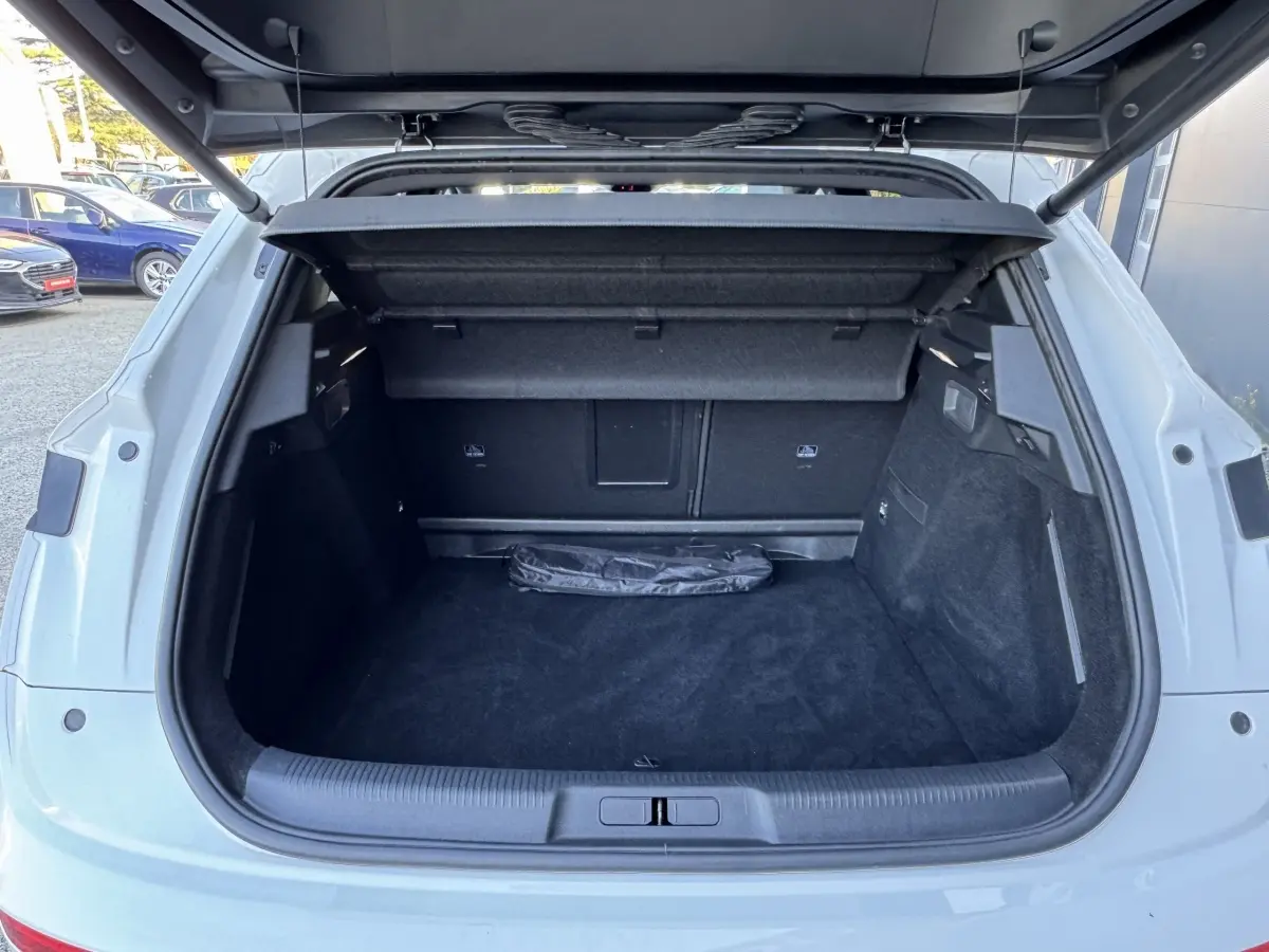 Coffre ouvert d’un DS7 Crossback blanc, vue arrière montrant l’espace de chargement et la tablette cache-bagages.