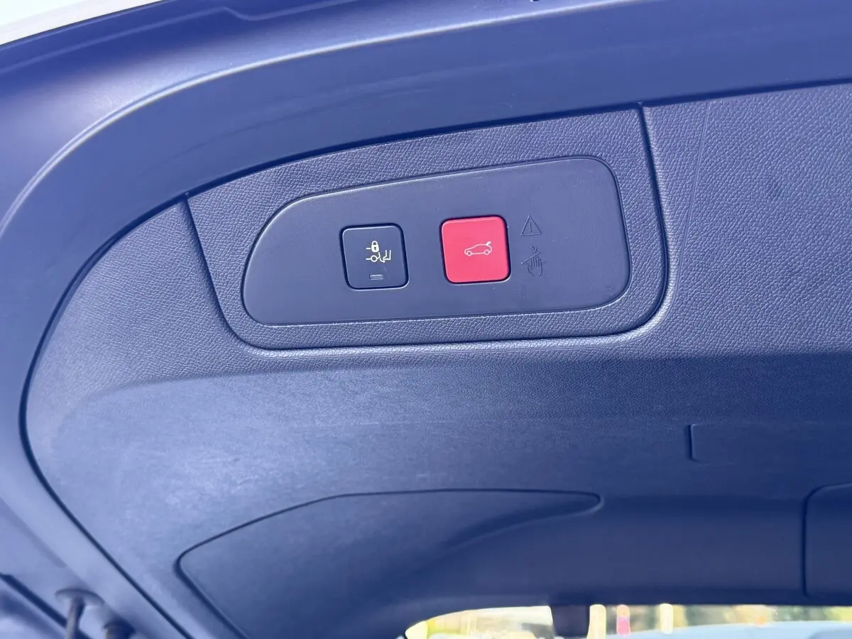 Gros plan sur le panneau de commandes du hayon électrique à l'intérieur du coffre d'un DS7 Crossback blanc.