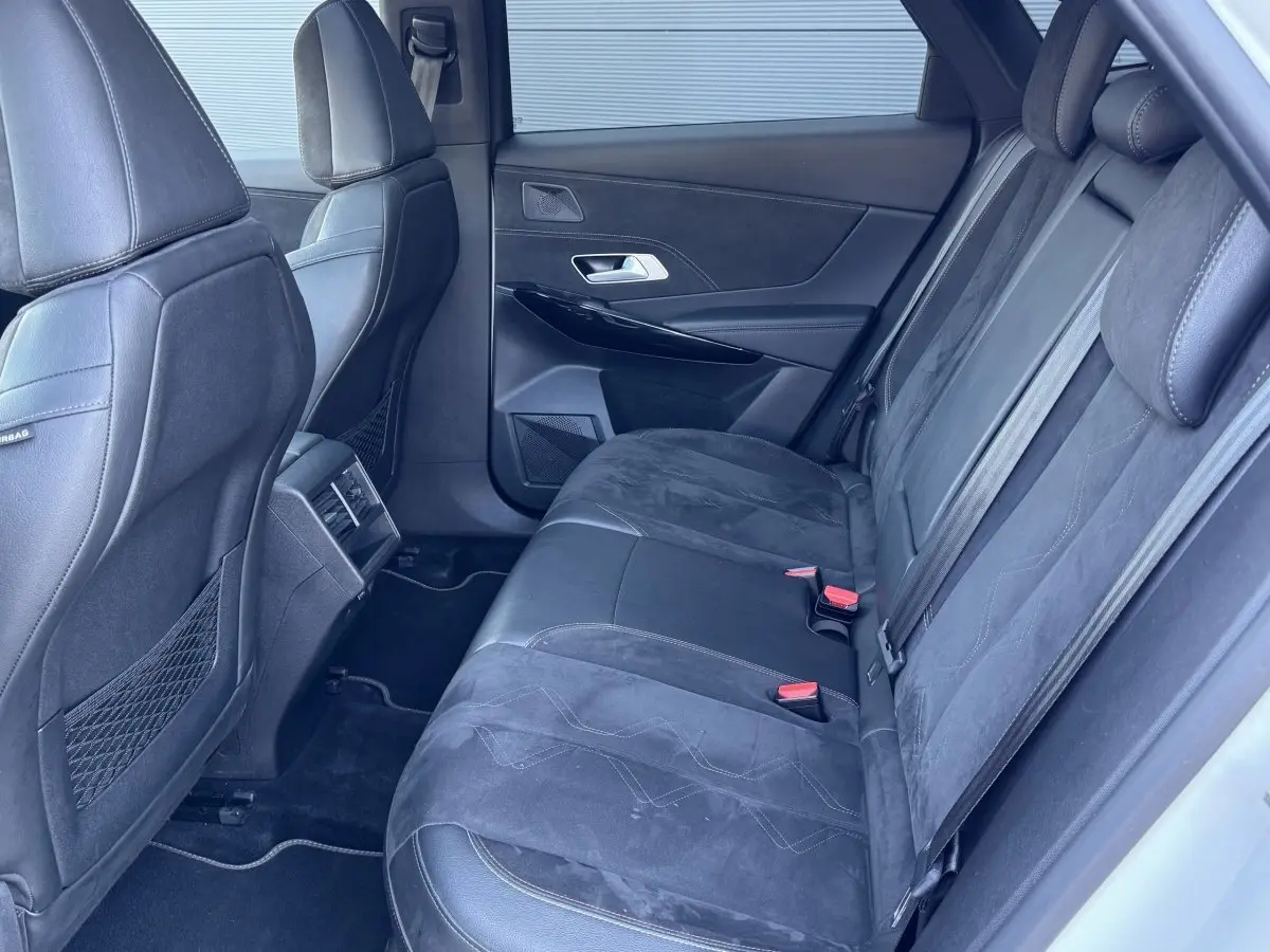 Vue intérieure côté droit des sièges arrière en cuir noir et alcantara du DS7 Crossback, avec appuie-têtes et ceintures visibles.