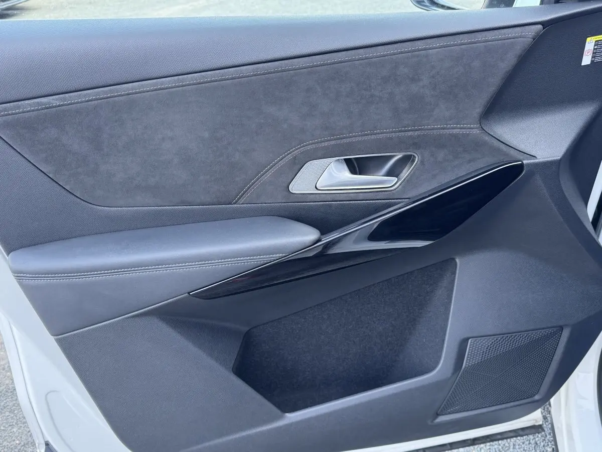 Vue rapprochée de la porte avant droite blanche du DS7 Crossback avec garniture noire et insert en alcantara.