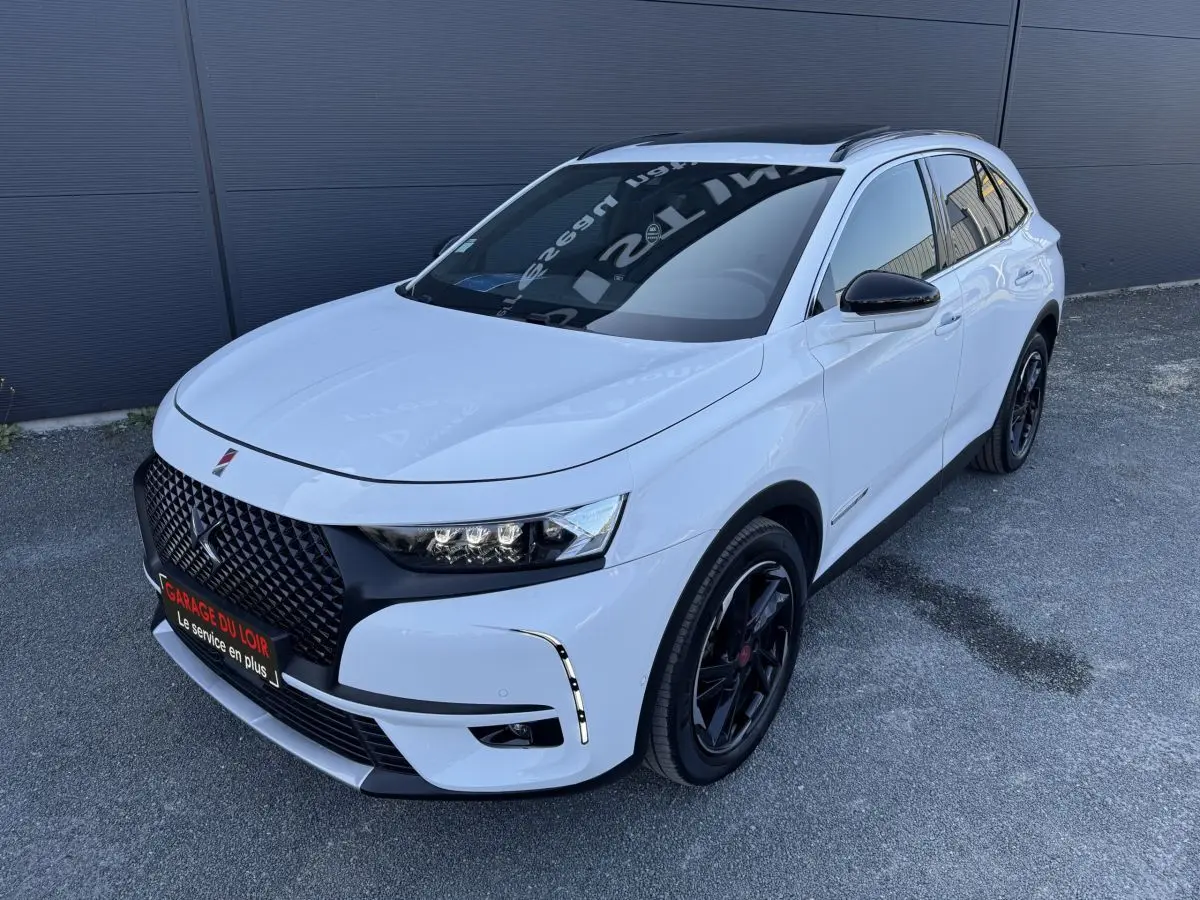DS7 Crossback blanc en vue 3/4 avant droit, avec calandre noire et jantes noires distinctives.
