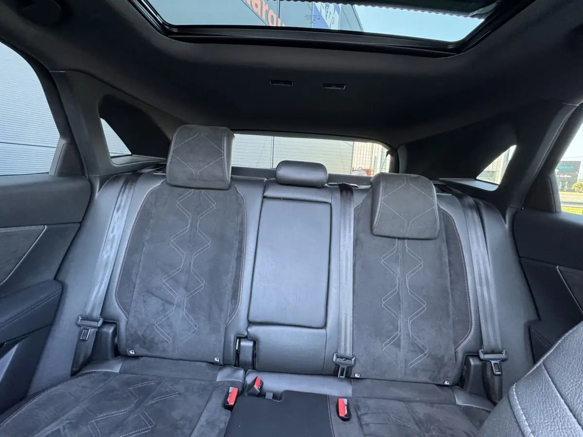 Vue intérieure arrière du DS7 Crossback 2020 montrant la banquette en cuir noir avec surpiqûres et toit ouvrant panoramique.