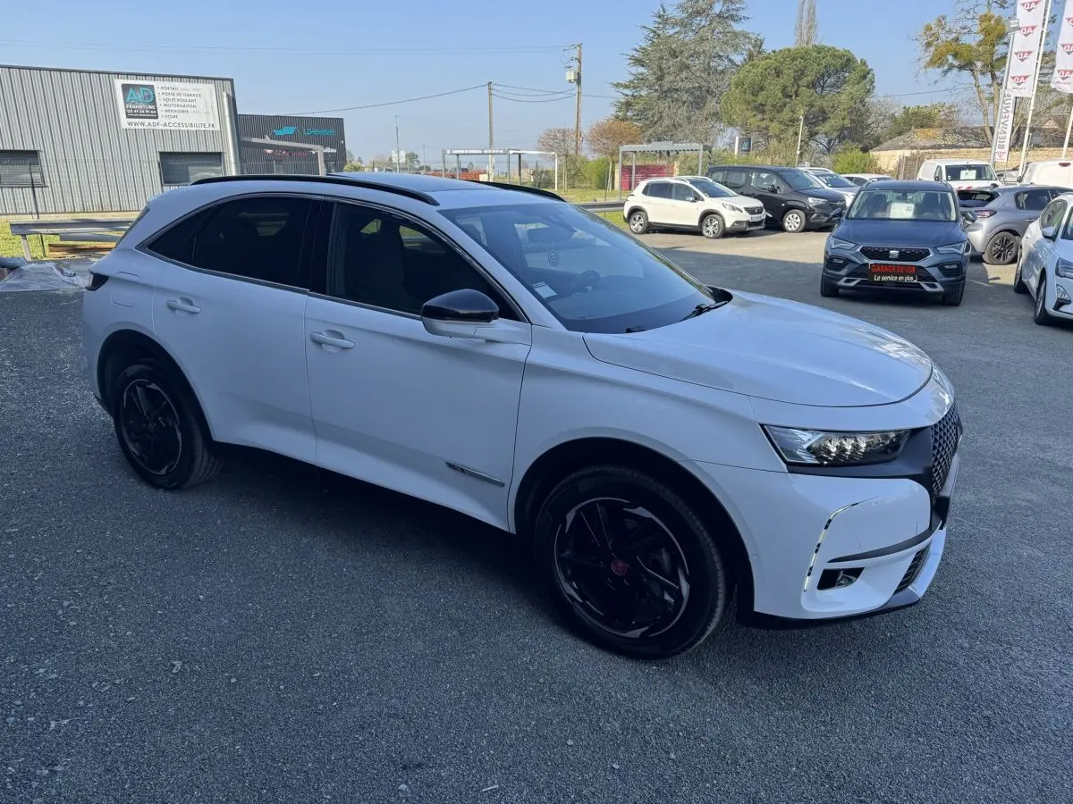 DS7 Crossback blanc vue 3/4 avant droit, avec jantes noires et calandre distinctive DS en concession.