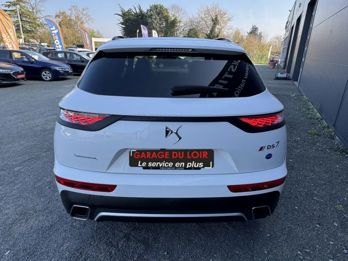 Vue arrière d'un DS7 Crossback blanc avec feux LED caractéristiques et double sortie d'échappement rectangulaire.