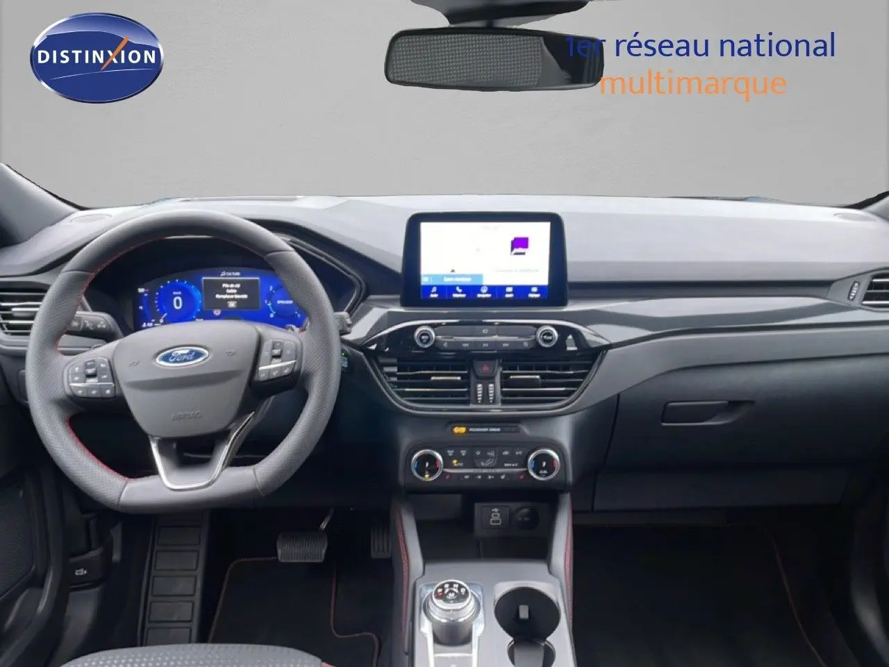 Vue intérieure frontale du tableau de bord du Ford Kuga 2024, avec volant multifonction et écran tactile central.