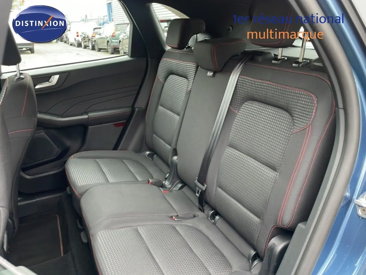 Vue intérieure côté droit des sièges arrière en tissu noir avec surpiqûres rouges du Ford Kuga bleu chrome 2024.