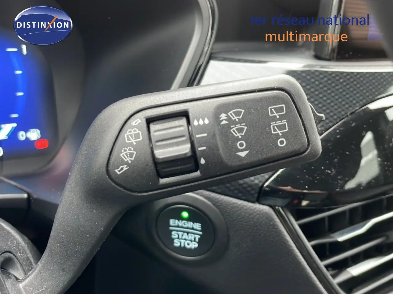 Détail du commodo d’essuie-glace avec bouton start/stop visible, intérieur noir du Ford Kuga 2024.