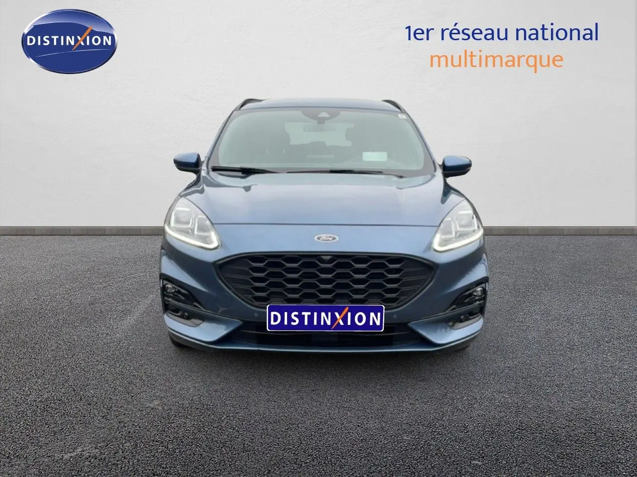 Vue frontale d'un Ford Kuga 2024 bleu chrome métal avec calandre noire et phares LED allumés.