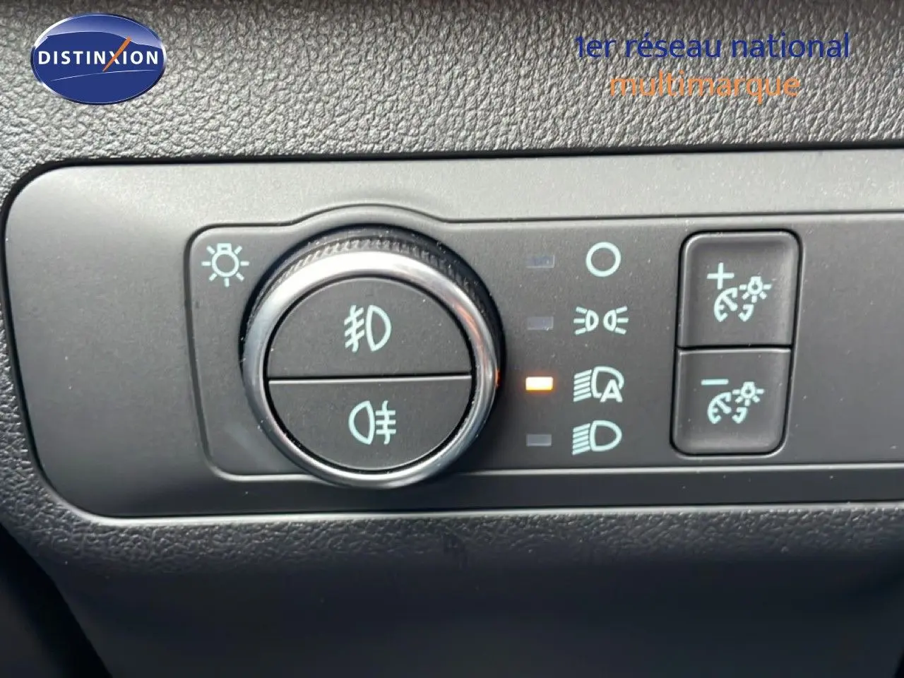 Gros plan sur le tableau de bord du Ford Kuga 2024, montrant la molette de réglage des phares et les commandes d’éclairage.