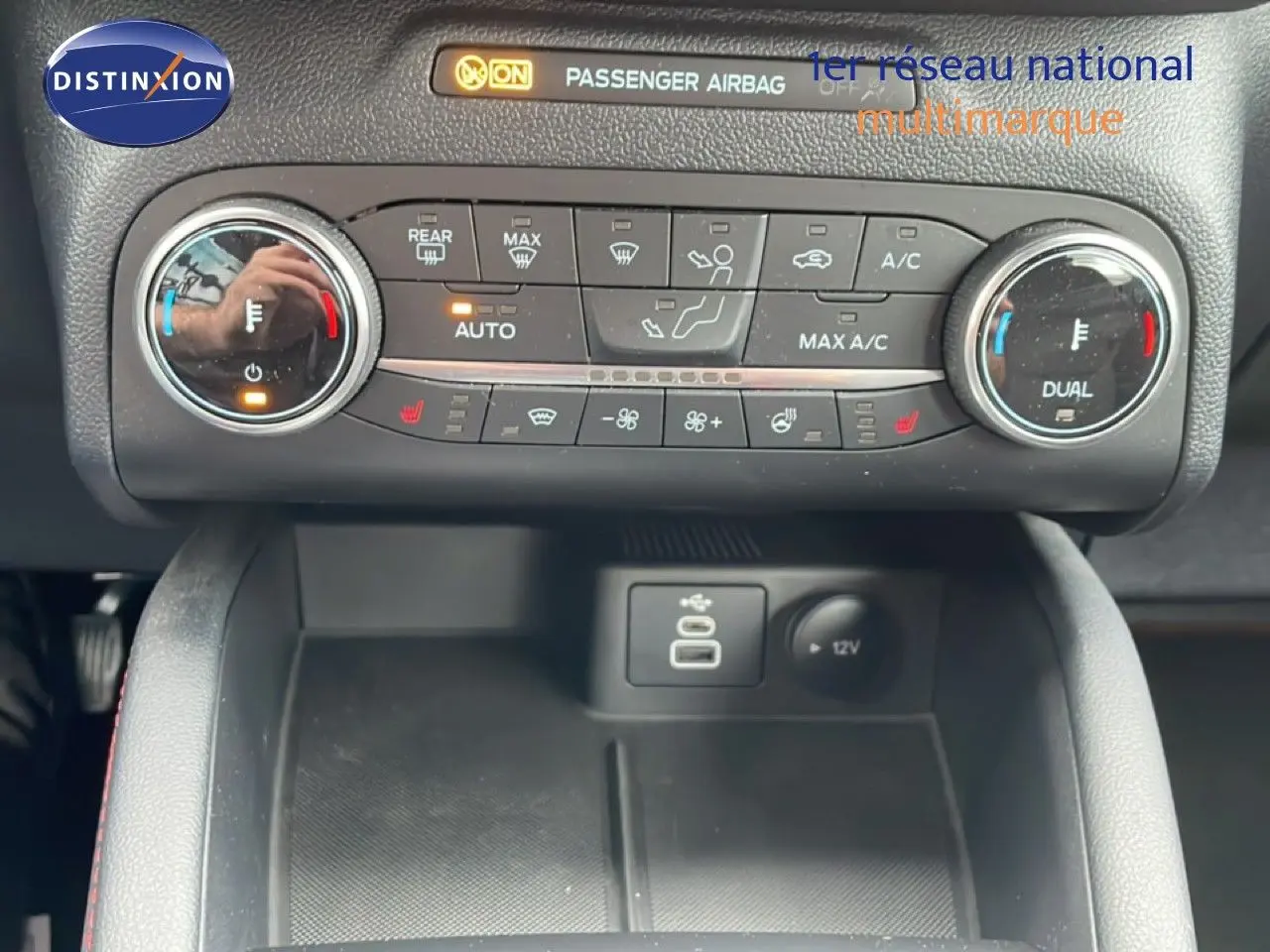 Vue rapprochée du tableau de bord central du Ford Kuga 2024, montrant les commandes de climatisation et ports USB.